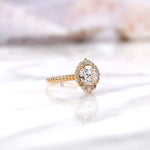Angled view highlighting halo diamonds and polished yellow gold band
