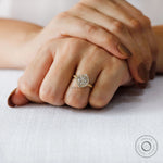 Lifestyle image of yellow gold halo engagement ring worn on hand