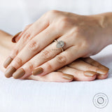 Pear halo engagement ring worn on hand