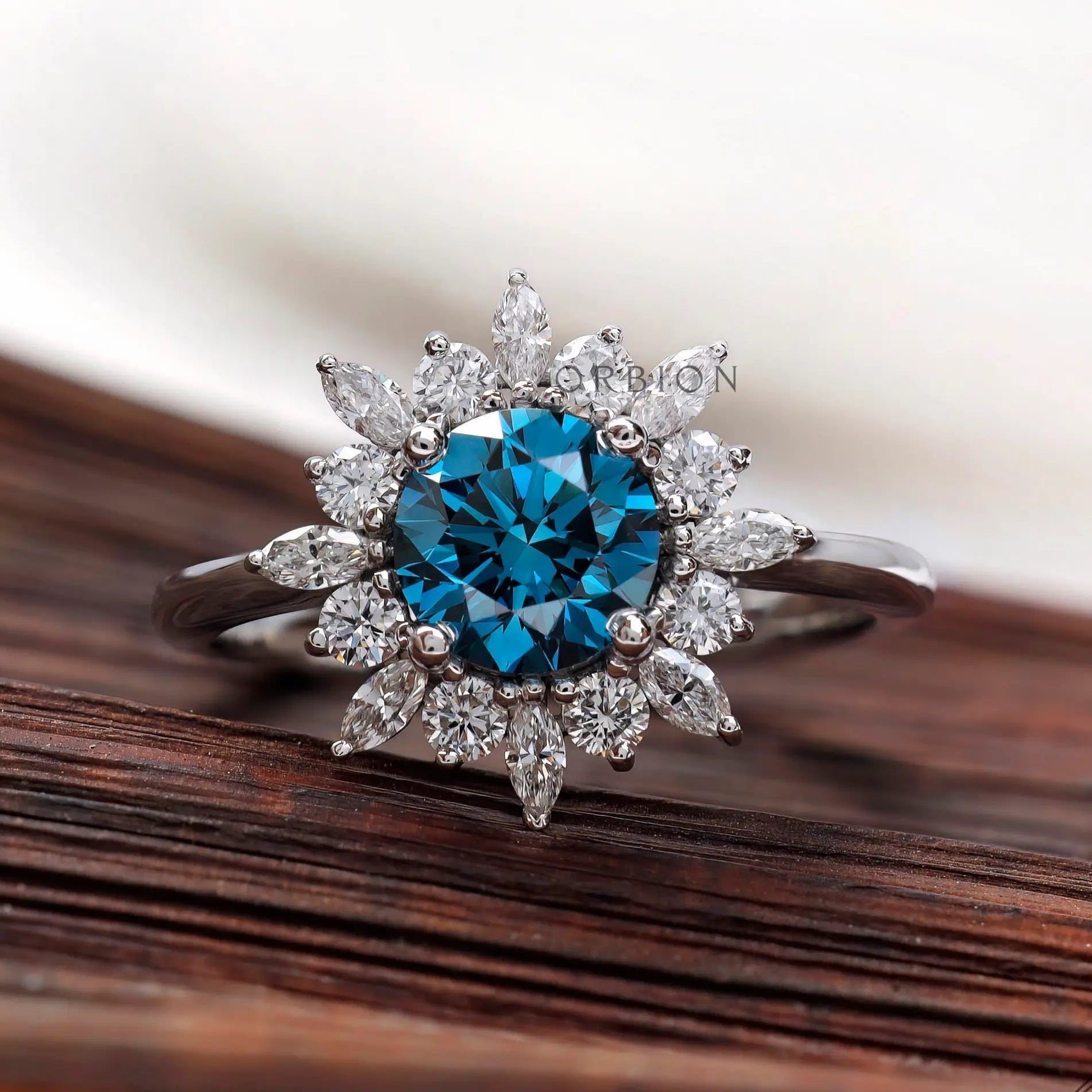 Round vivid blue diamond ring with marquise halo