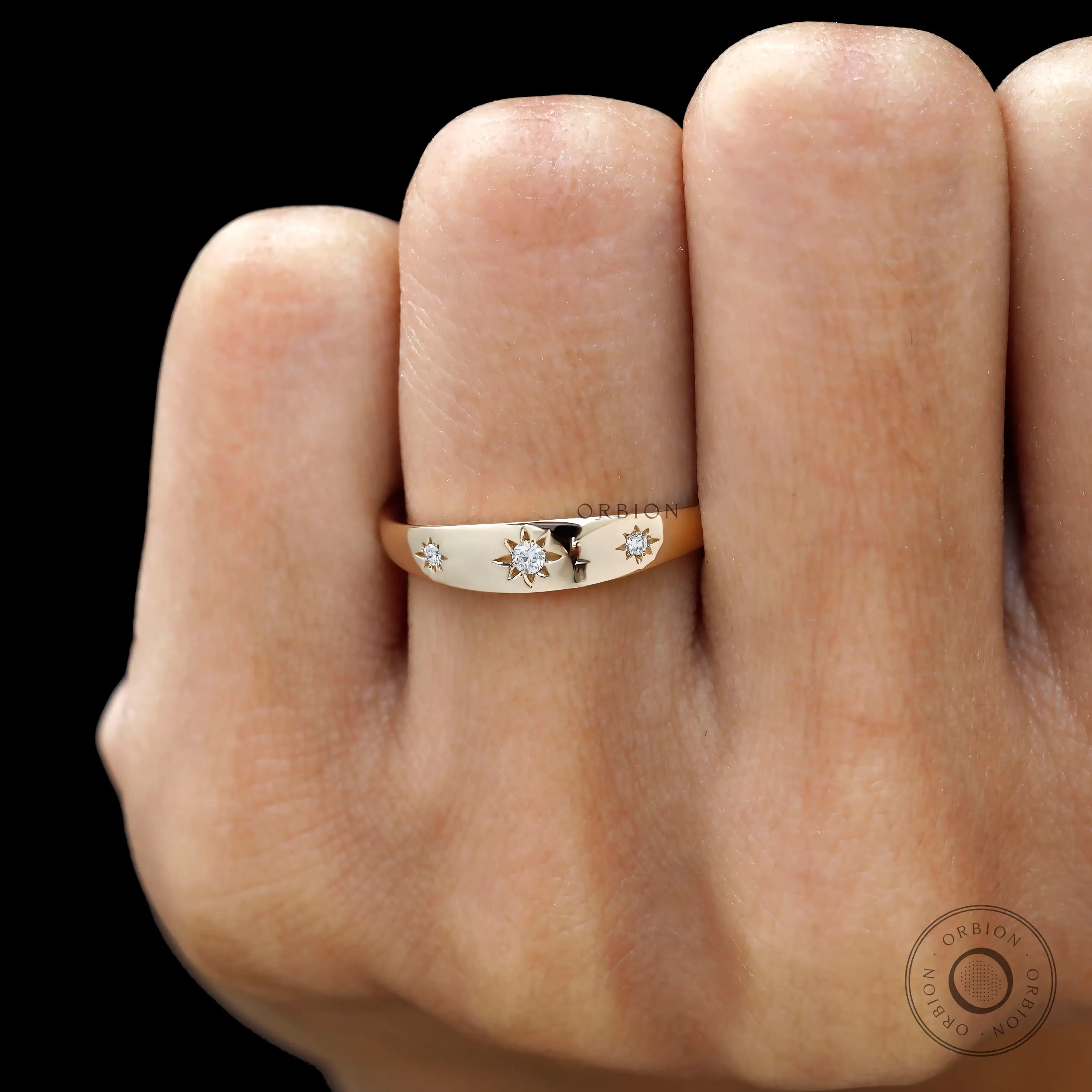 Front worn view of yellow gold band featuring three starburst diamonds.