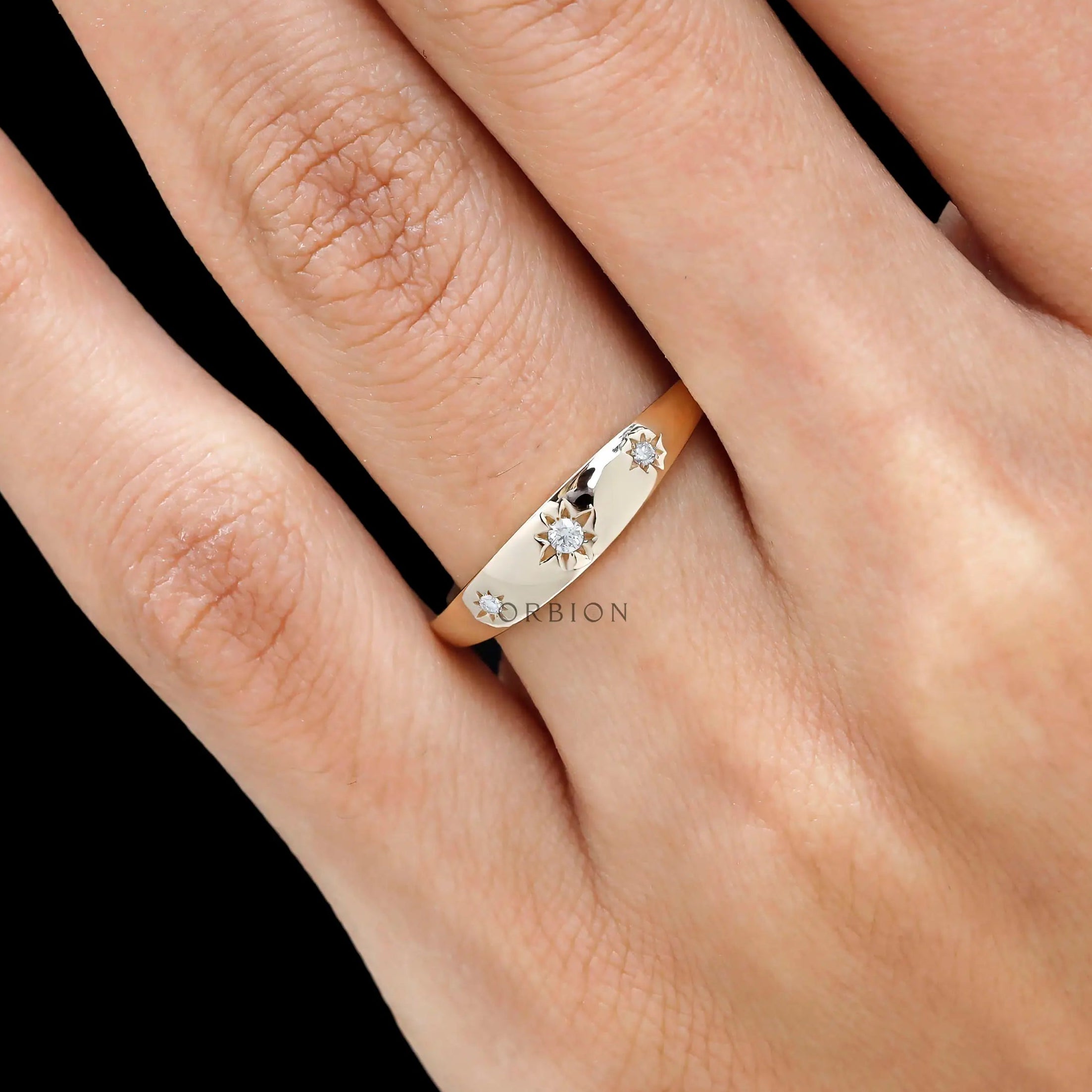 Side close view of yellow gold band with starburst set diamonds.