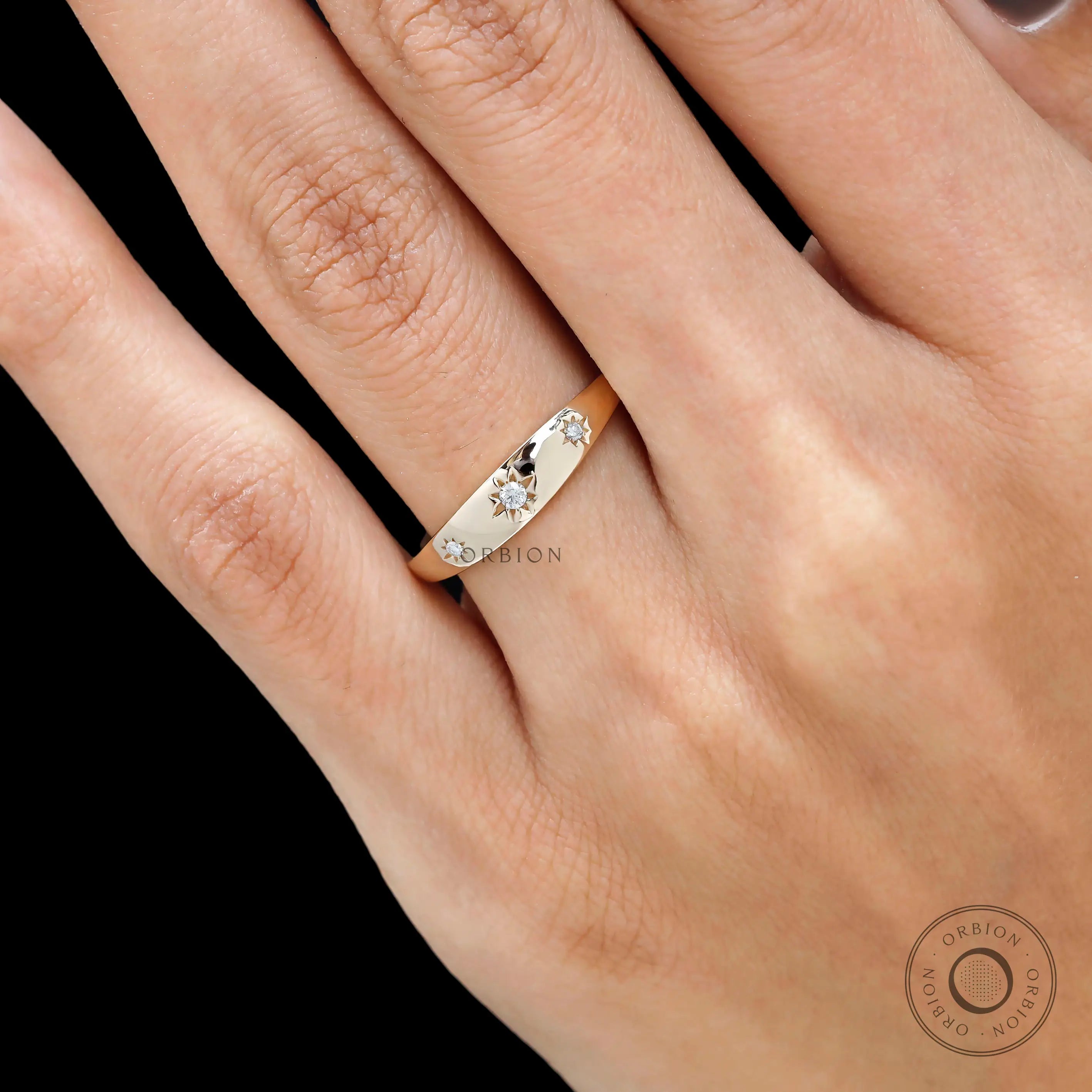 Side close view of yellow gold band with starburst set diamonds.