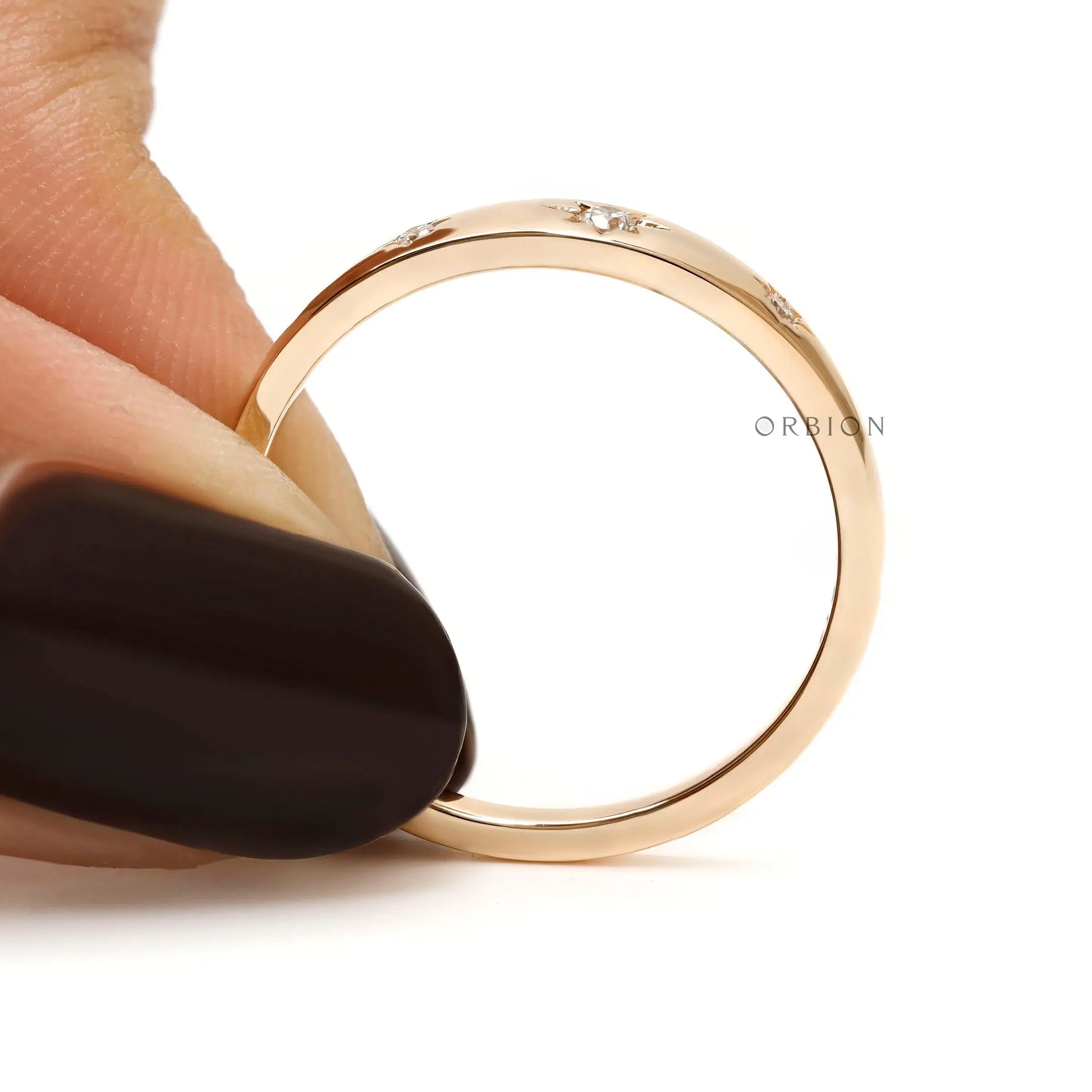 Front held view of gold band with three starburst diamond accents.