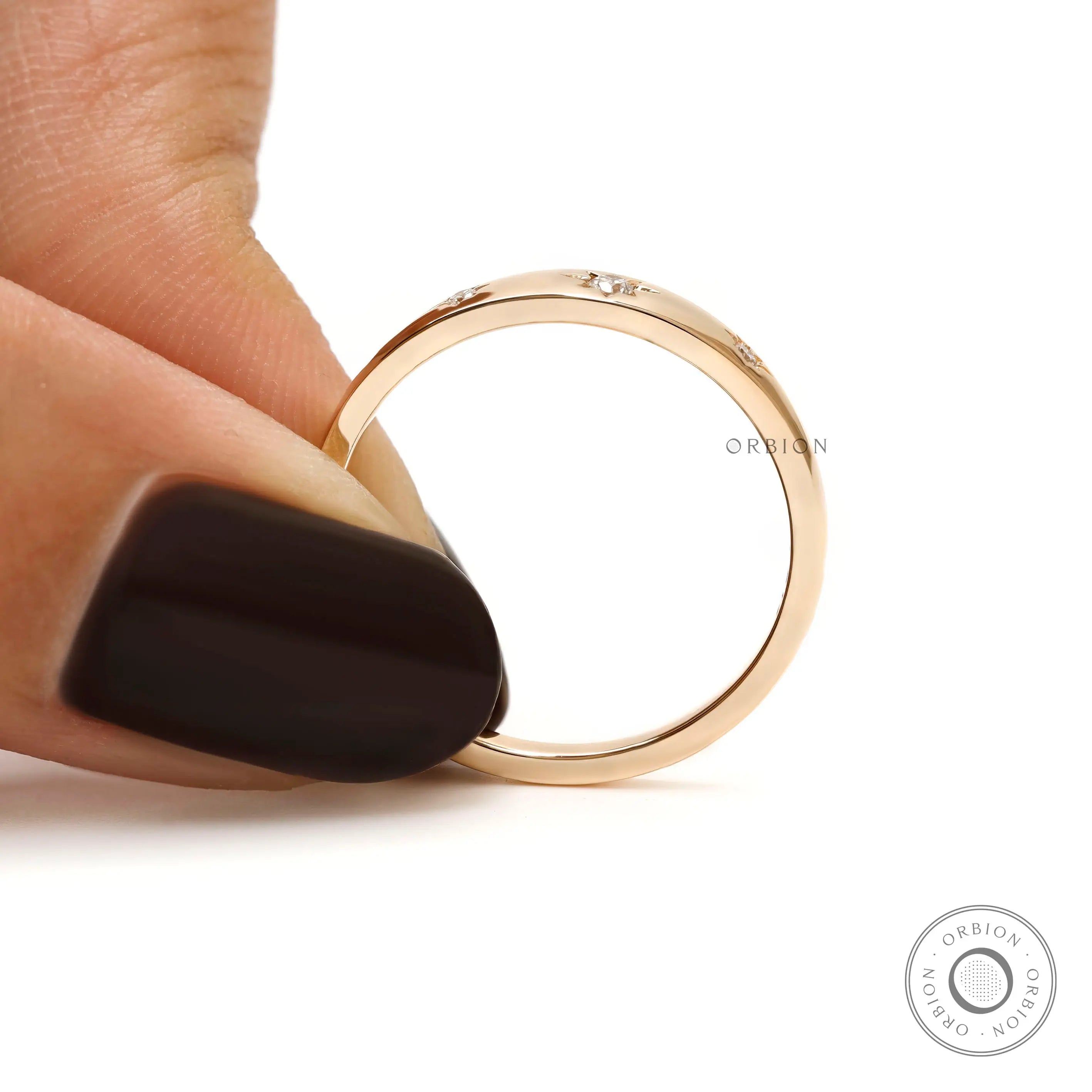 Front held view of gold band with three starburst diamond accents.
