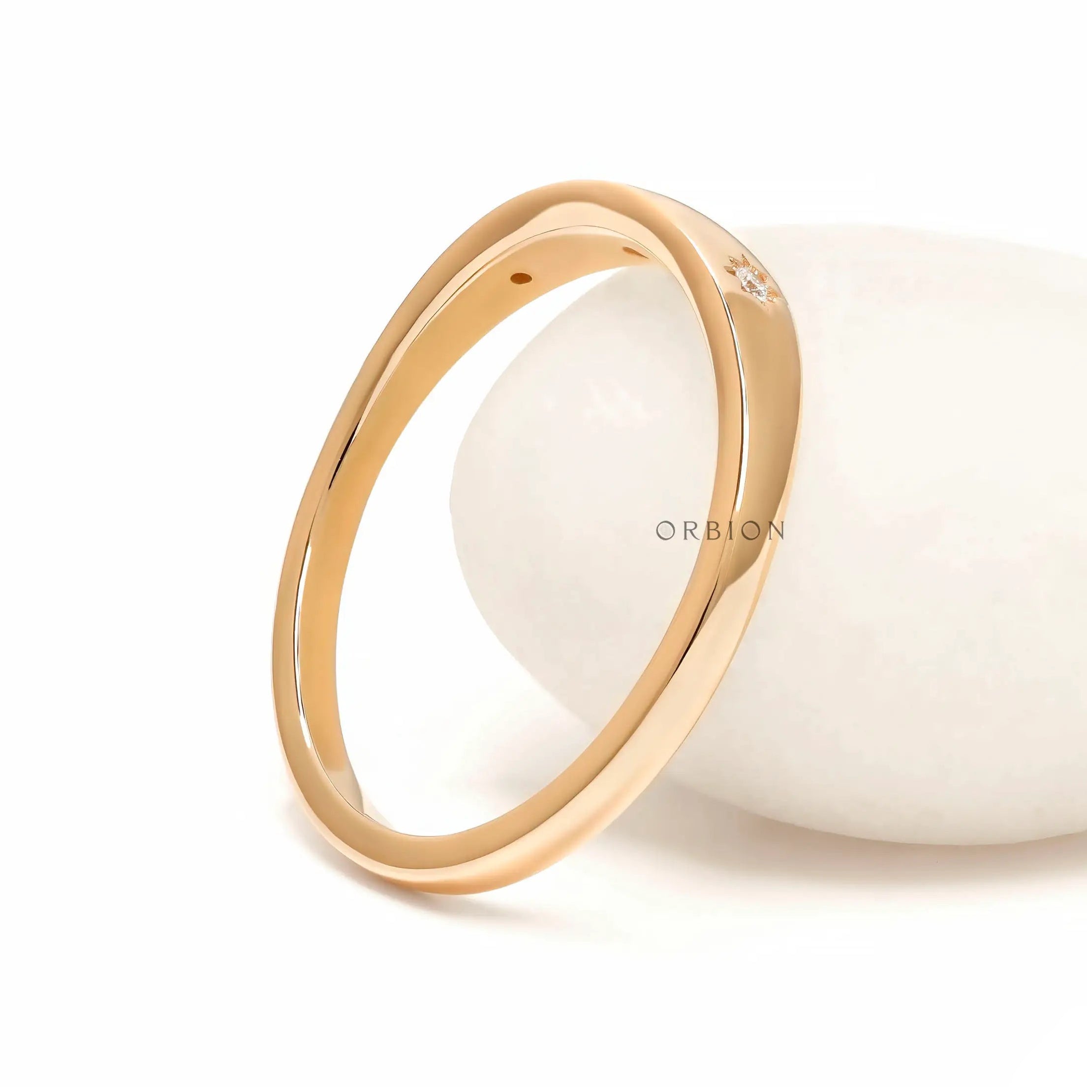 Back angled view of polished yellow gold band with slim profile.