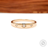 Front view of yellow gold band with three starburst set diamonds.
