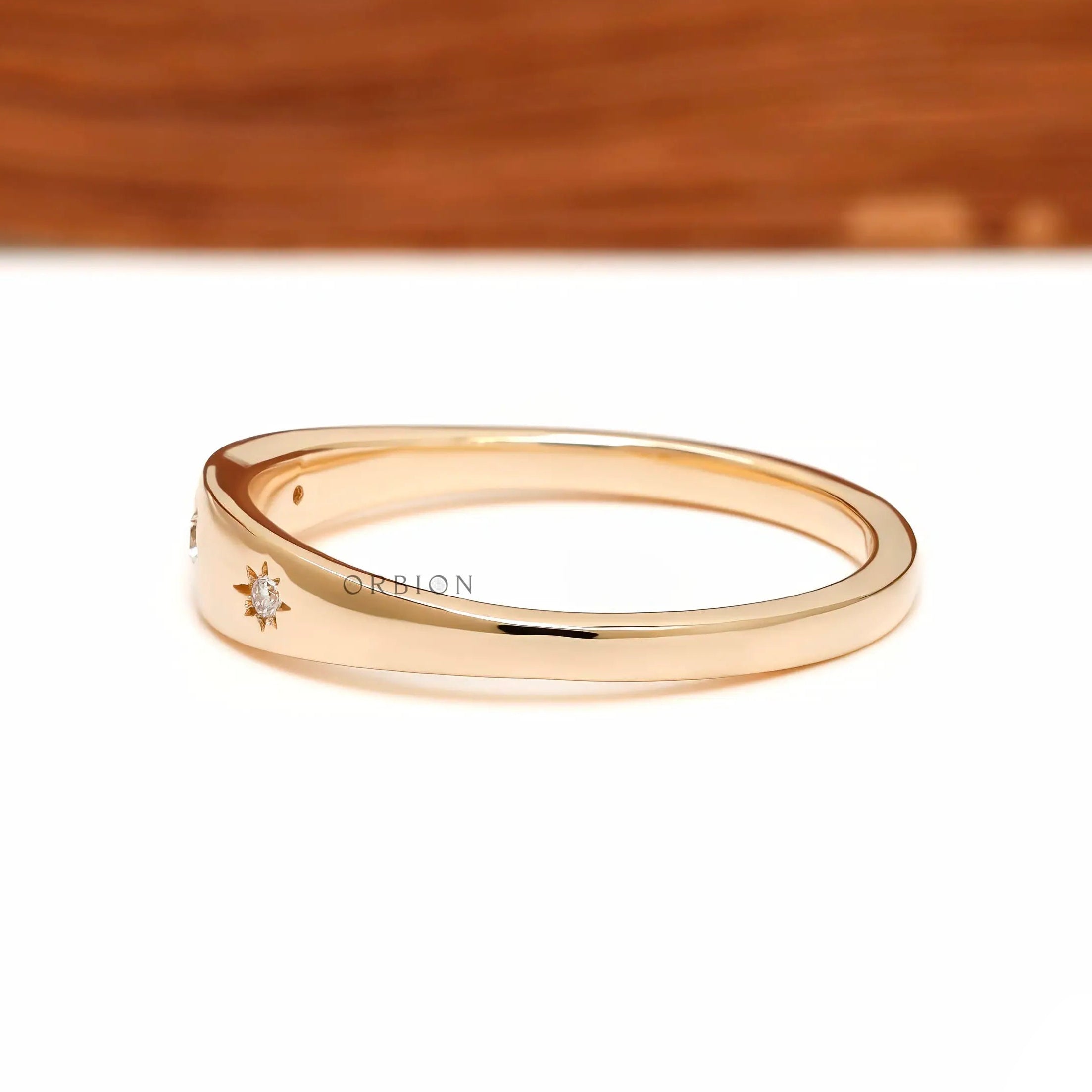 Side profile of yellow gold starburst diamond band with smooth taper.