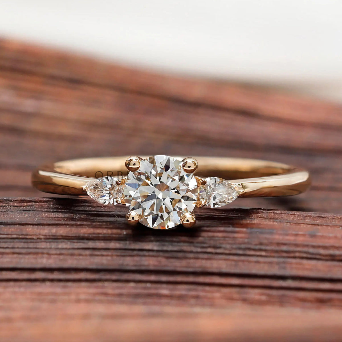Round cut lab grown diamond three stone ring in yellow gold front view