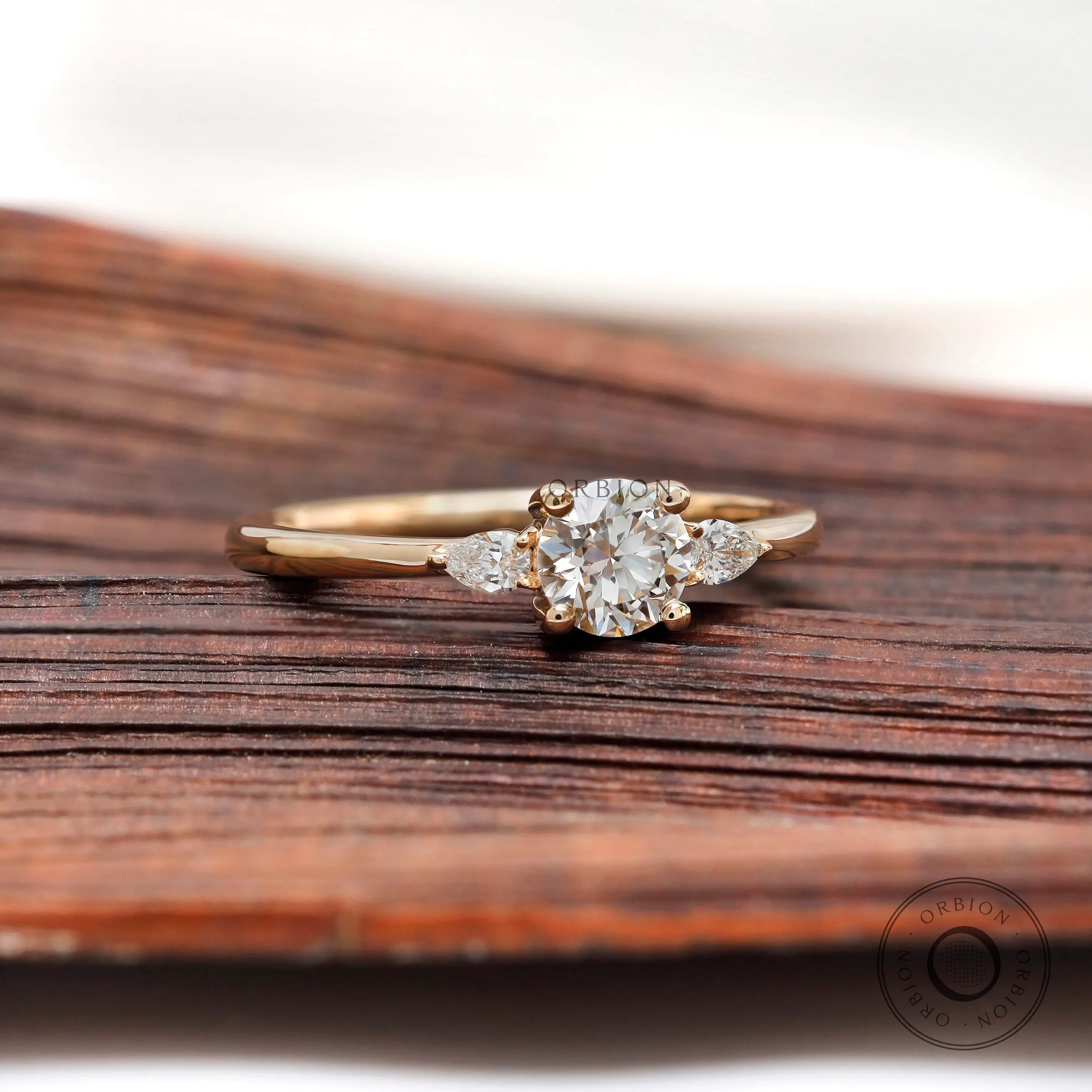 Straight on view of round diamond ring with pear side stones
