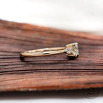 Side profile of three stone diamond ring showing slim band