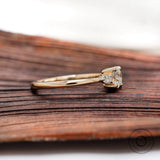 Side profile of three stone diamond ring showing slim band
