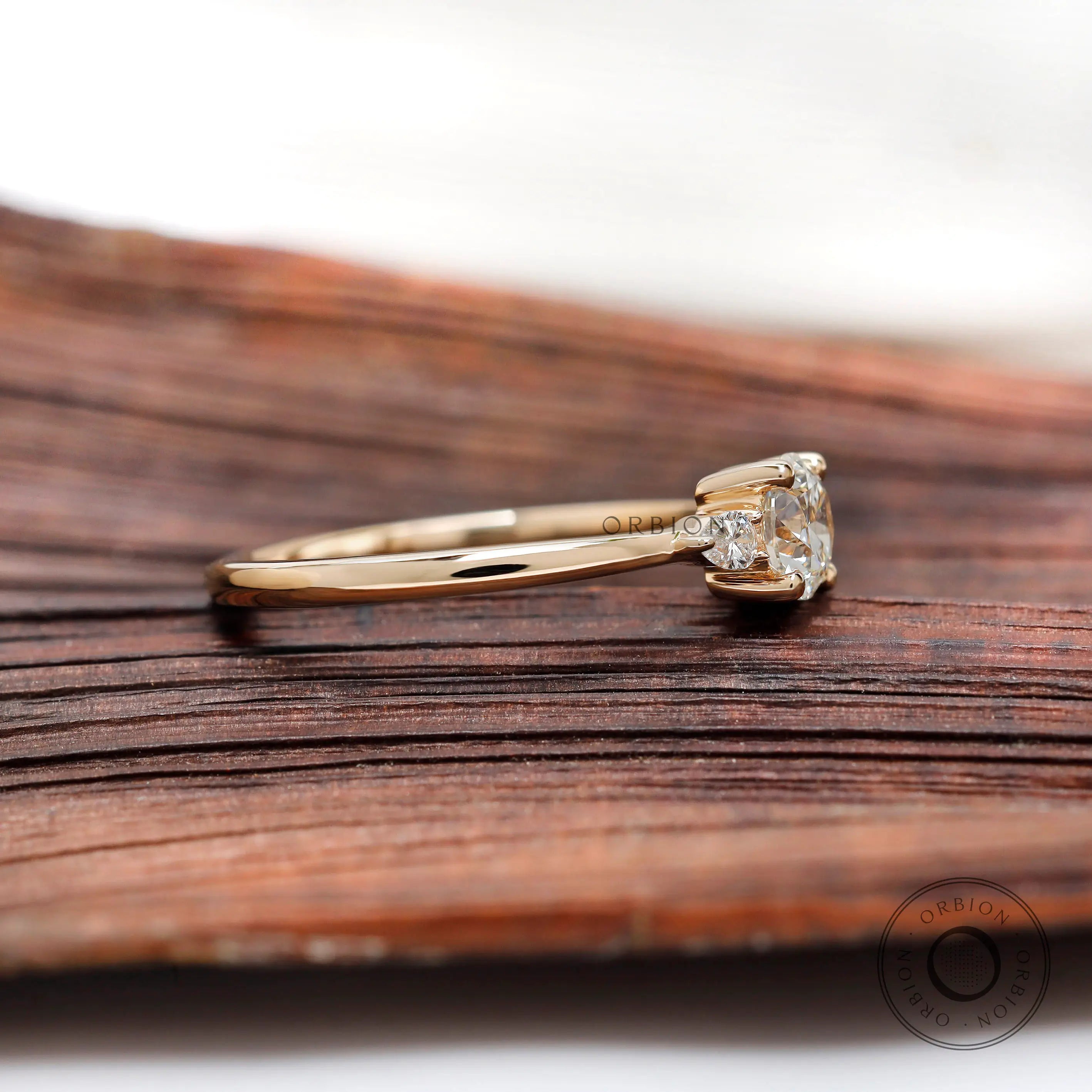 Side profile of three stone diamond ring showing slim band