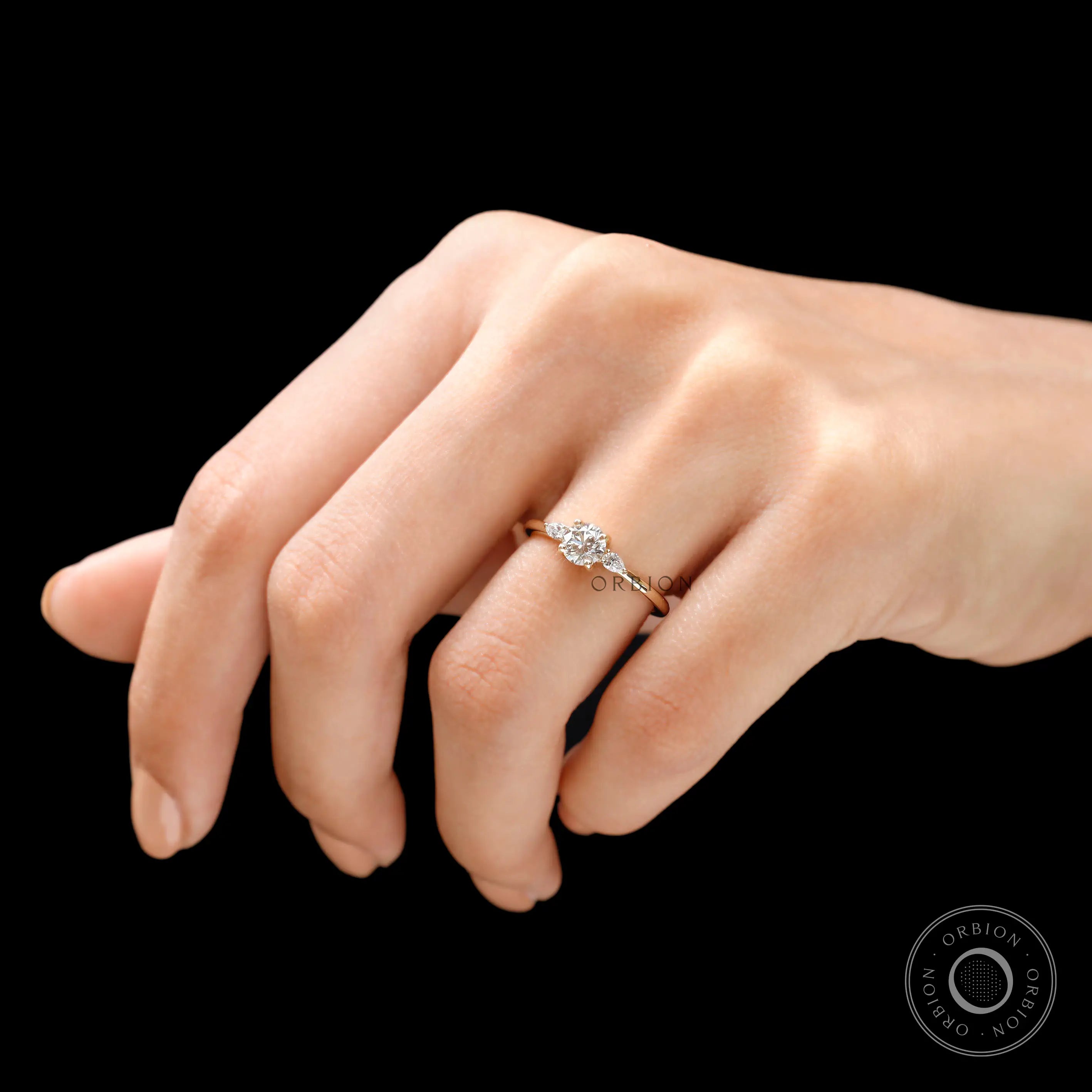 Close up of round brilliant center diamond with pear side stones