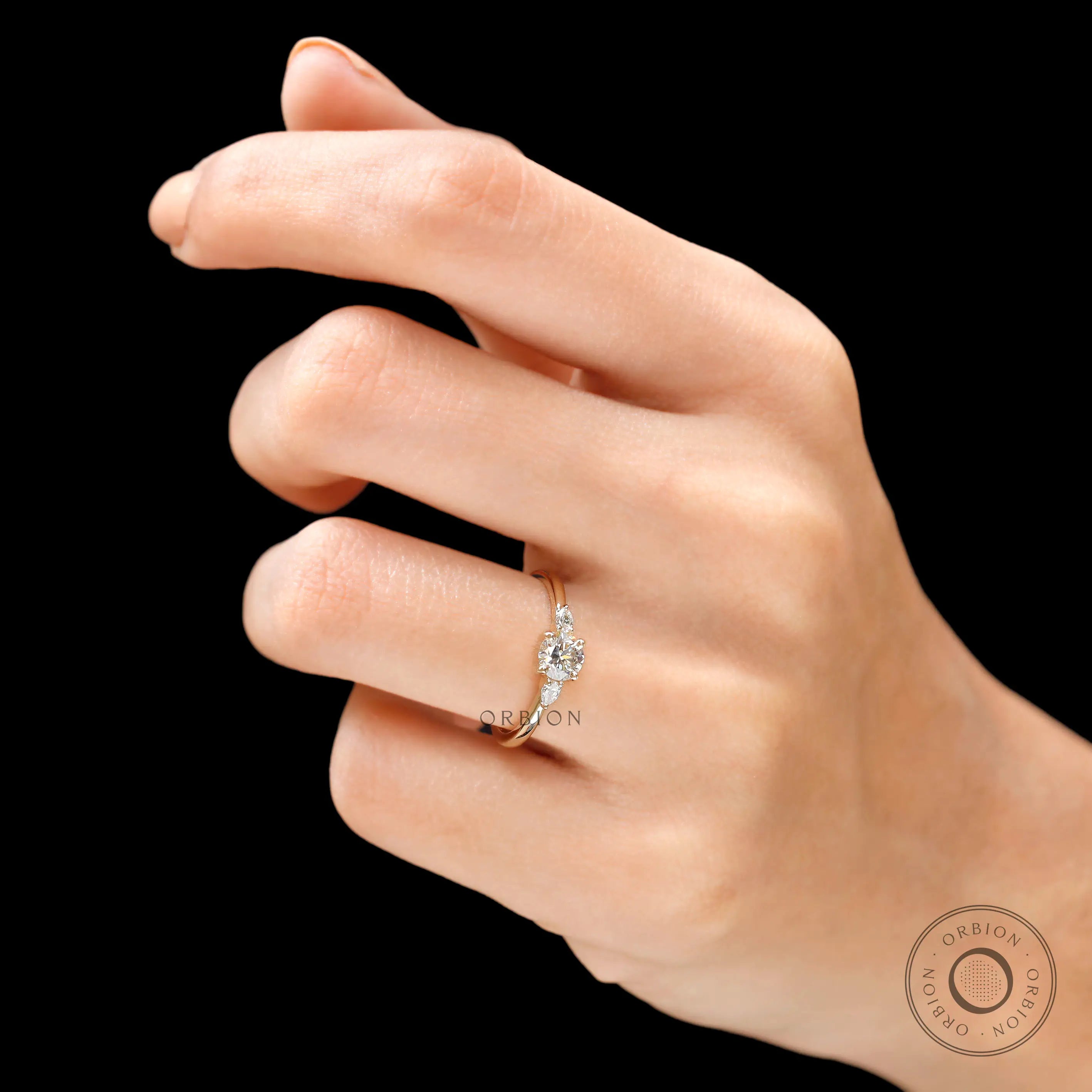 Three stone lab grown diamond ring worn on hand top view