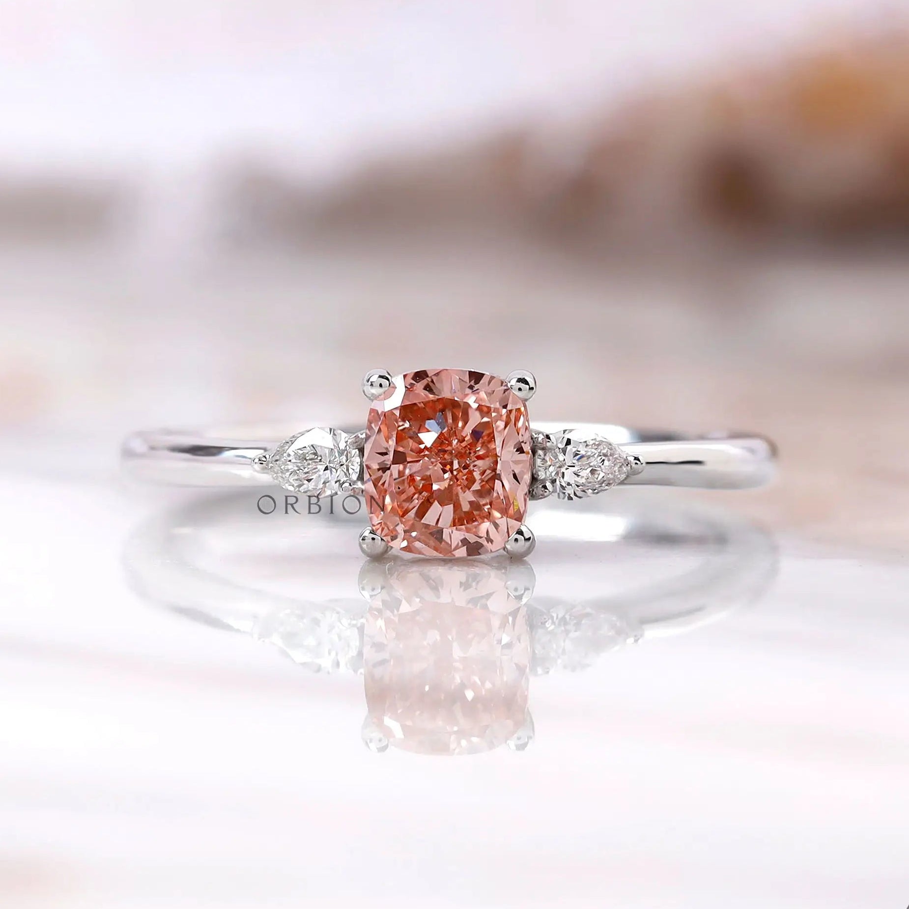 Cushion cut pink diamond ring with pear side stones