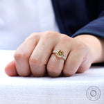 Yellow gold moissanite engagement ring worn on hand