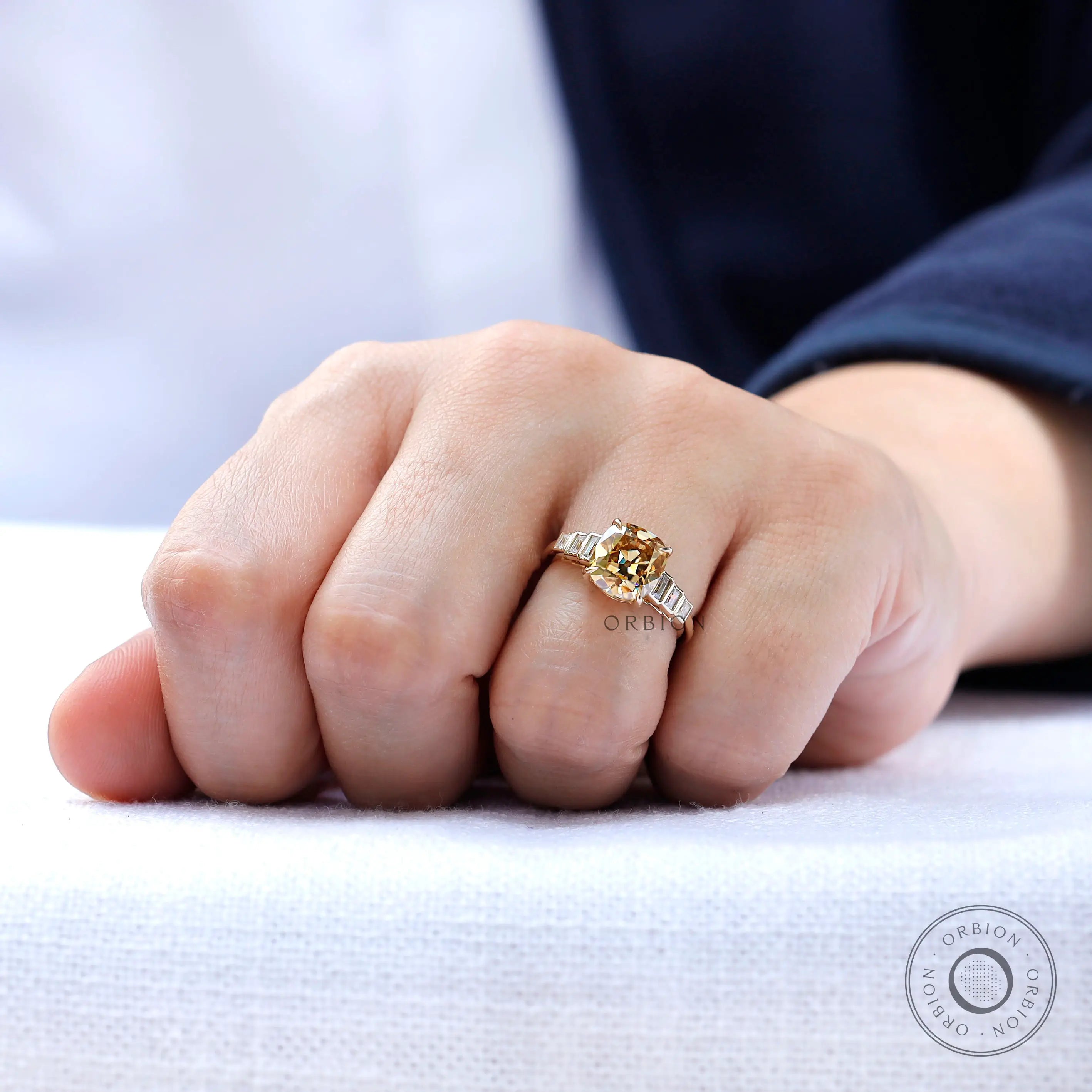 Yellow gold moissanite engagement ring worn on hand
