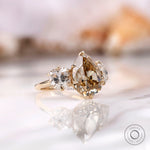 Pear shaped champagne moissanite with cushion side stones
