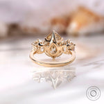 Crown style prong setting with pear center stone