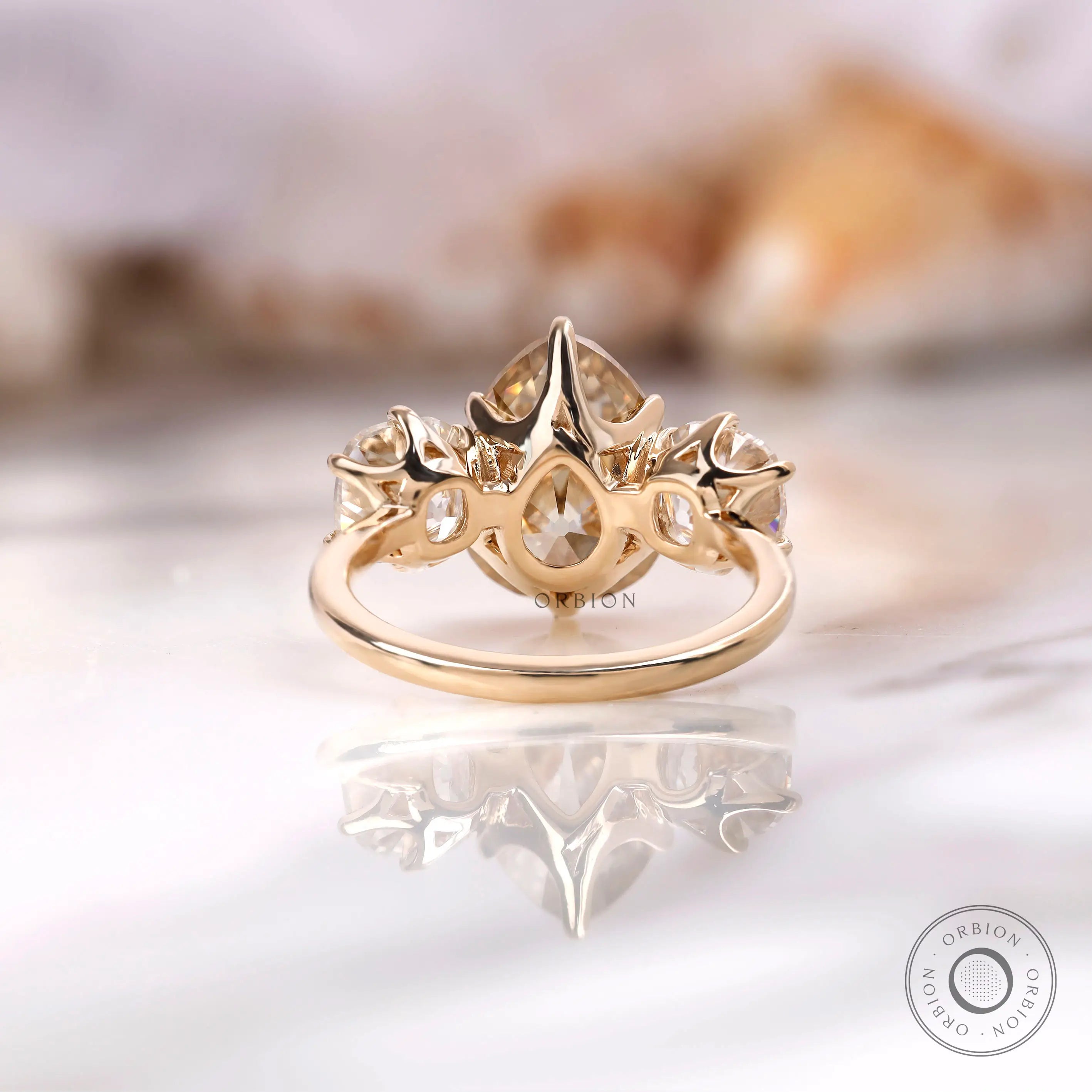 Crown style prong setting with pear center stone