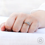Finger view from angle emphasizing centre stone brilliance