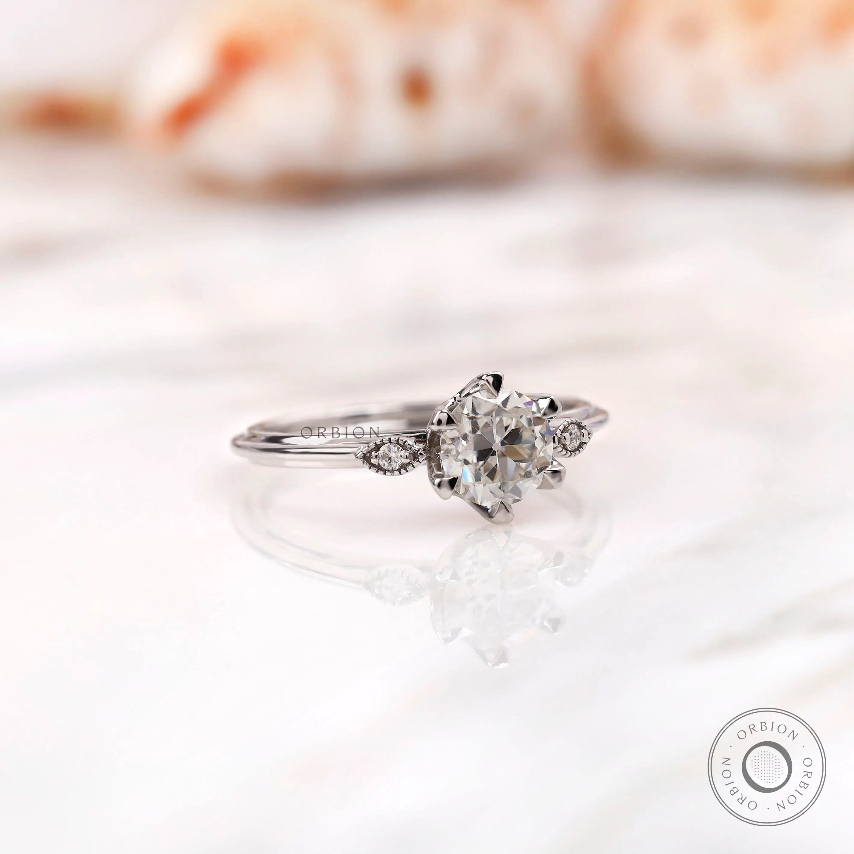 Angled close-up highlighting moissanite trio and milgrain texture