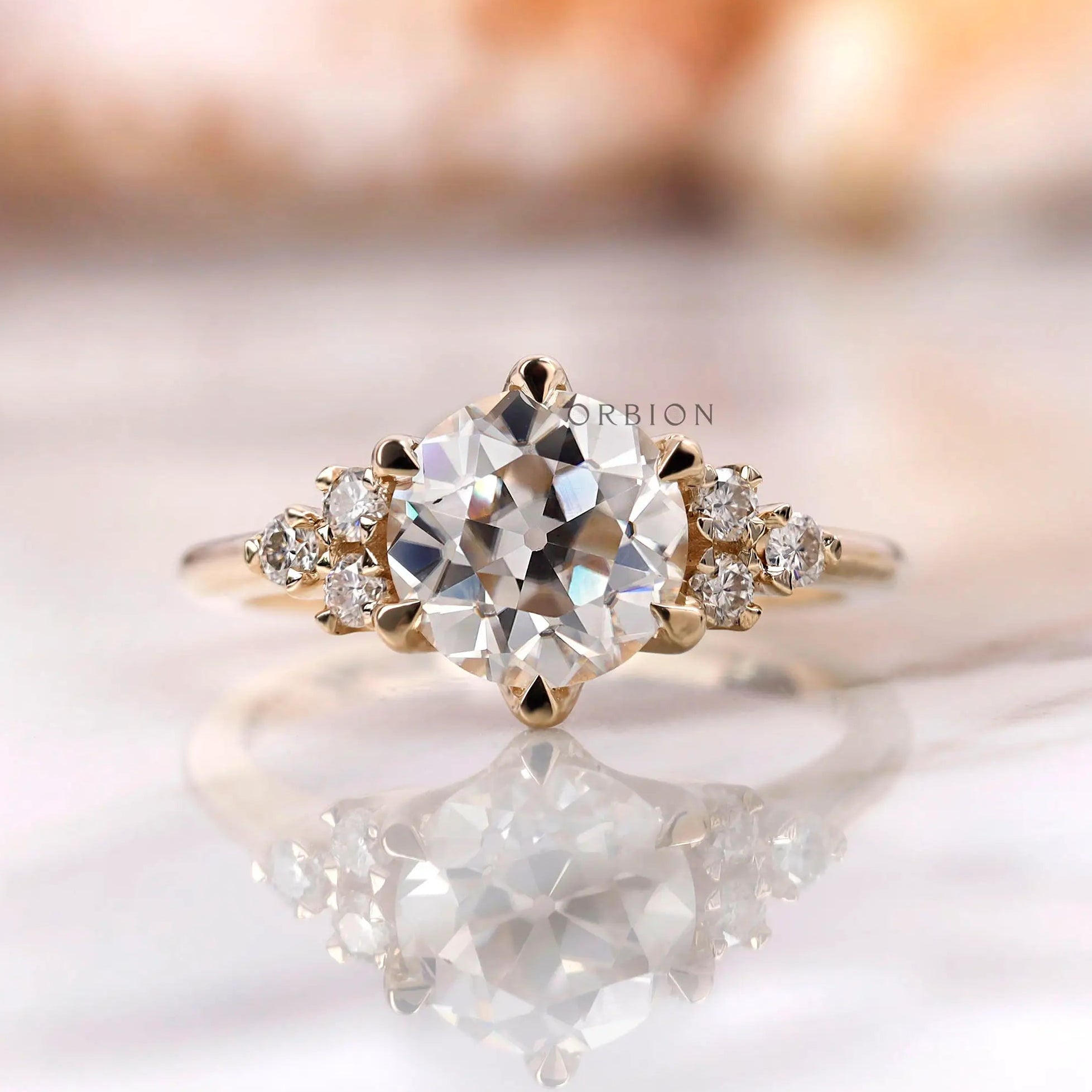 Front view of OEC Moissanite cluster engagement ring in yellow gold.