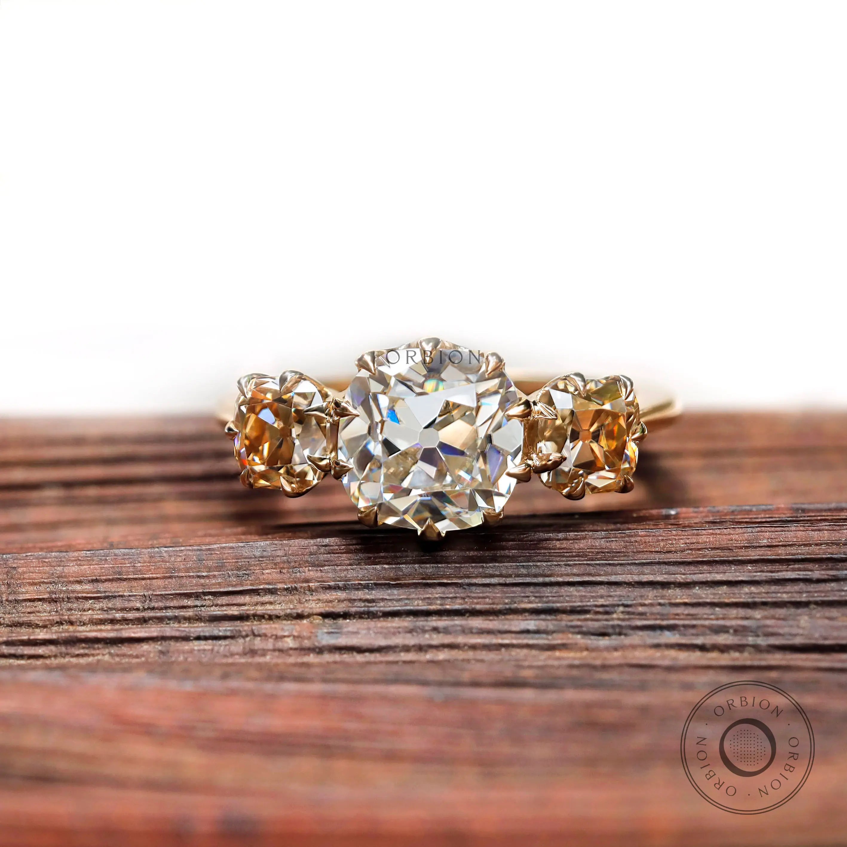 Three stone cushion Old Mine Cut moissanite ring in yellow gold front view