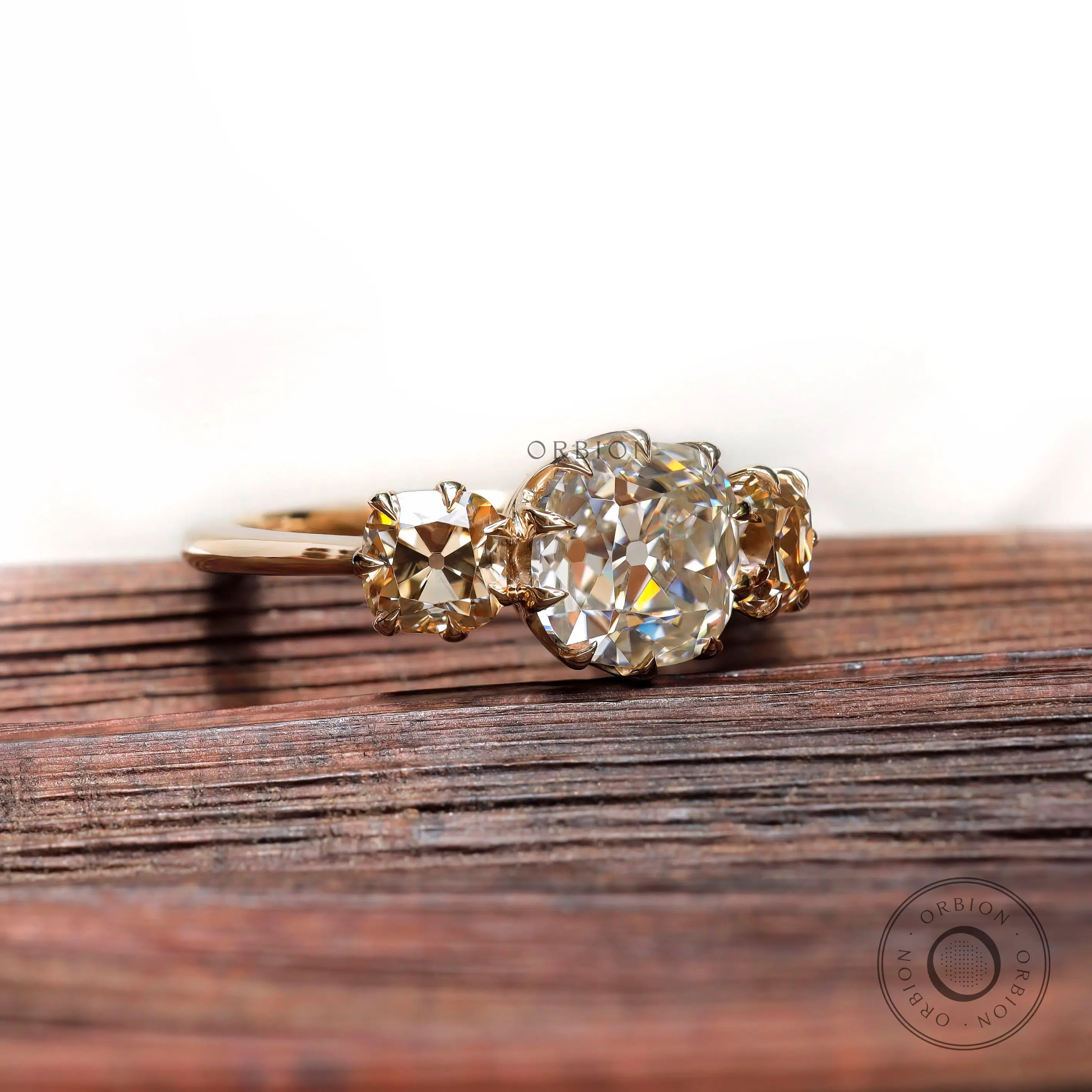 Vintage style moissanite engagement ring with champagne side stones close up