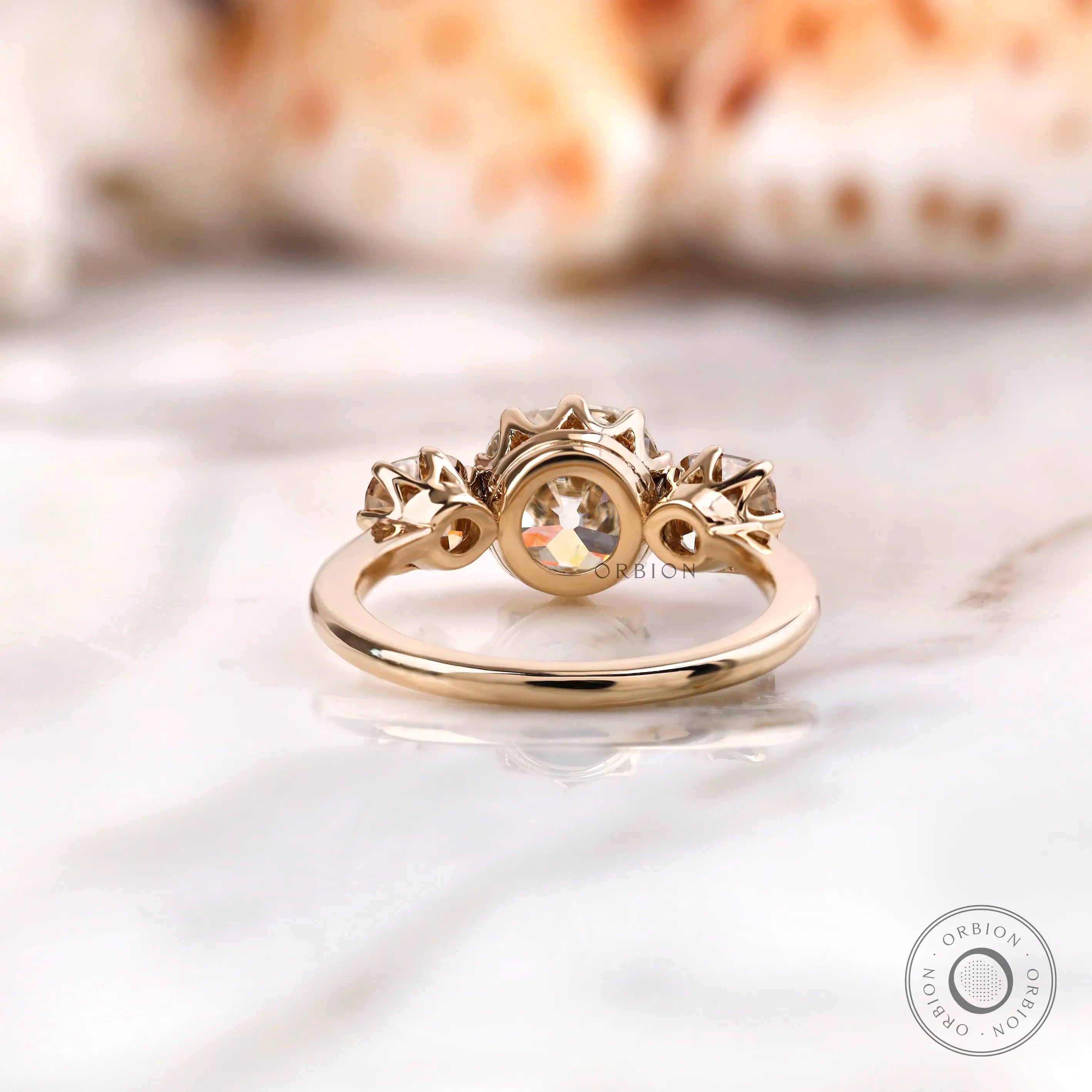 Back view of yellow gold three stone engagement ring structure