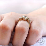 Close up of prong setting and side stones in three stone ring