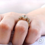 Close up of prong setting and side stones in three stone ring