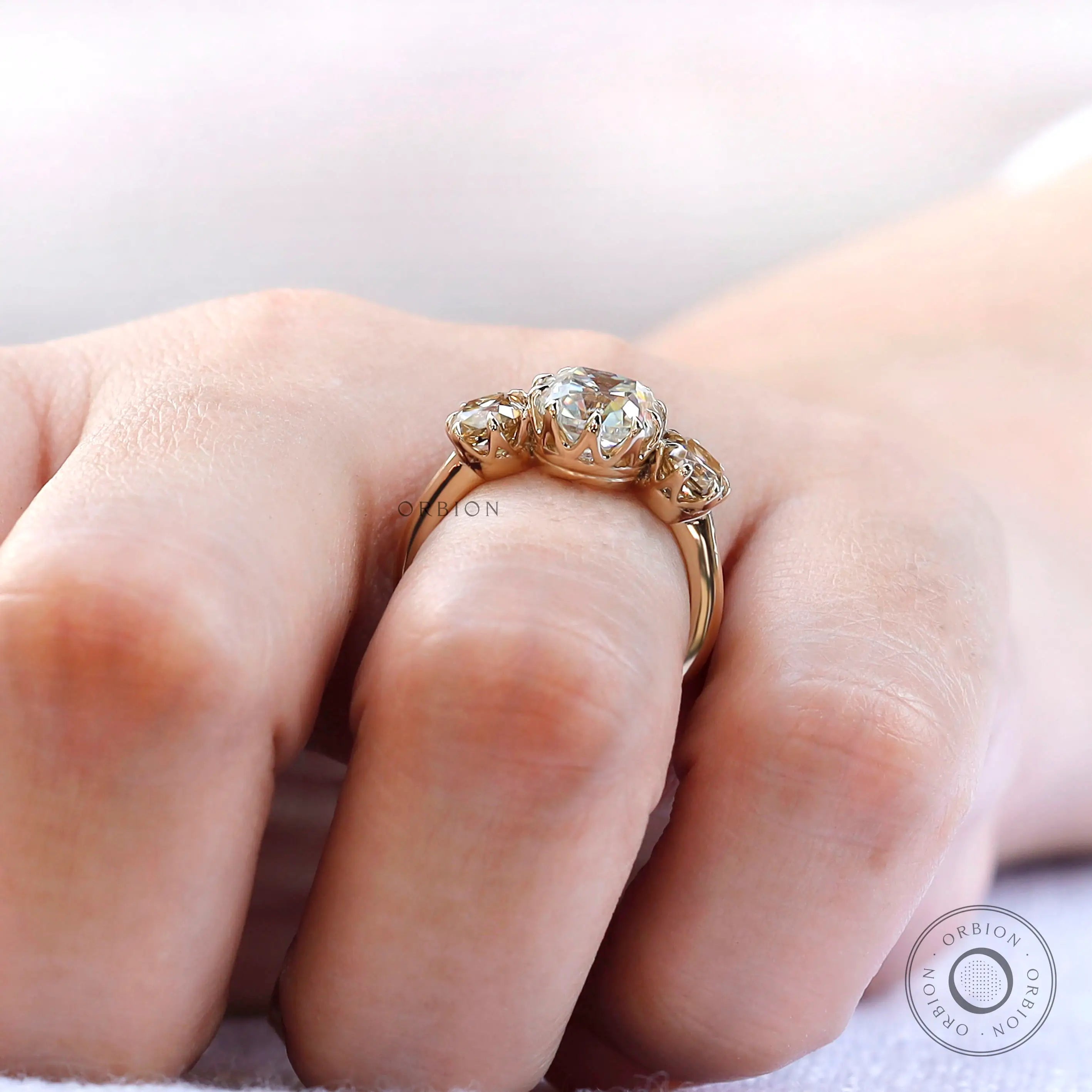 Close up of prong setting and side stones in three stone ring