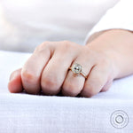 Close up of cushion moissanite bezel ring on hand in solid yellow gold