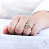 Close up of cushion moissanite bezel ring on hand in solid yellow gold