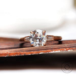 Round Old European Cut moissanite cathedral three stone ring in rose gold front view