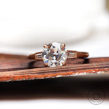 Round Old European Cut moissanite cathedral three stone ring in rose gold front view