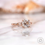 Angled view highlighting baguette side stones on rose gold moissanite ring