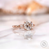 Angled view highlighting baguette side stones on rose gold moissanite ring