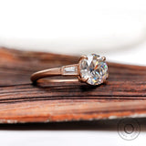 Angled view of cathedral three stone moissanite ring with baguette side stones