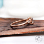 Side profile of cathedral style moissanite ring in 10K rose gold