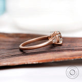 Side profile of cathedral style moissanite ring in 10K rose gold