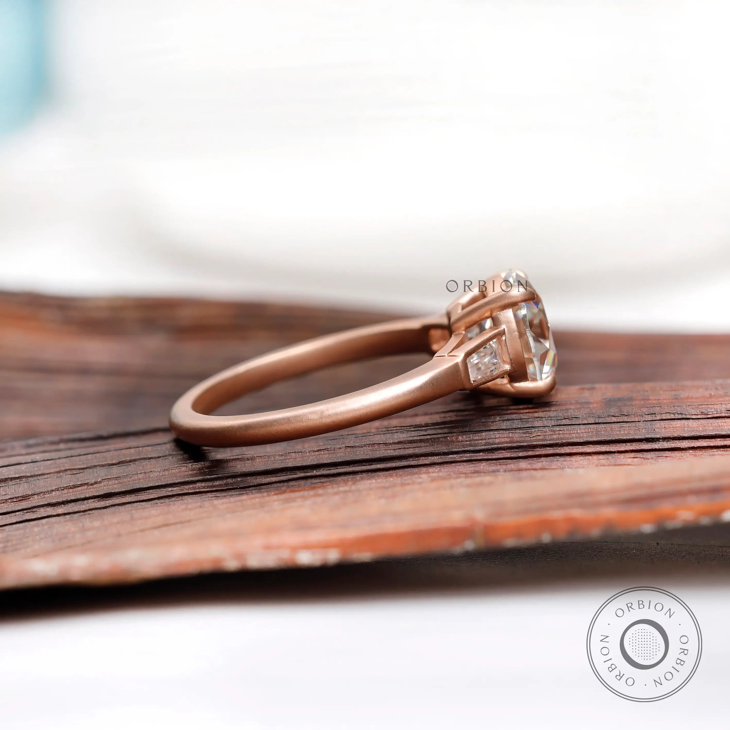 Side profile of cathedral style moissanite ring in 10K rose gold