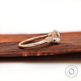 Side view of Moissanite three-stone ring with round Old European cut center and baguette stones in 10K yellow gold