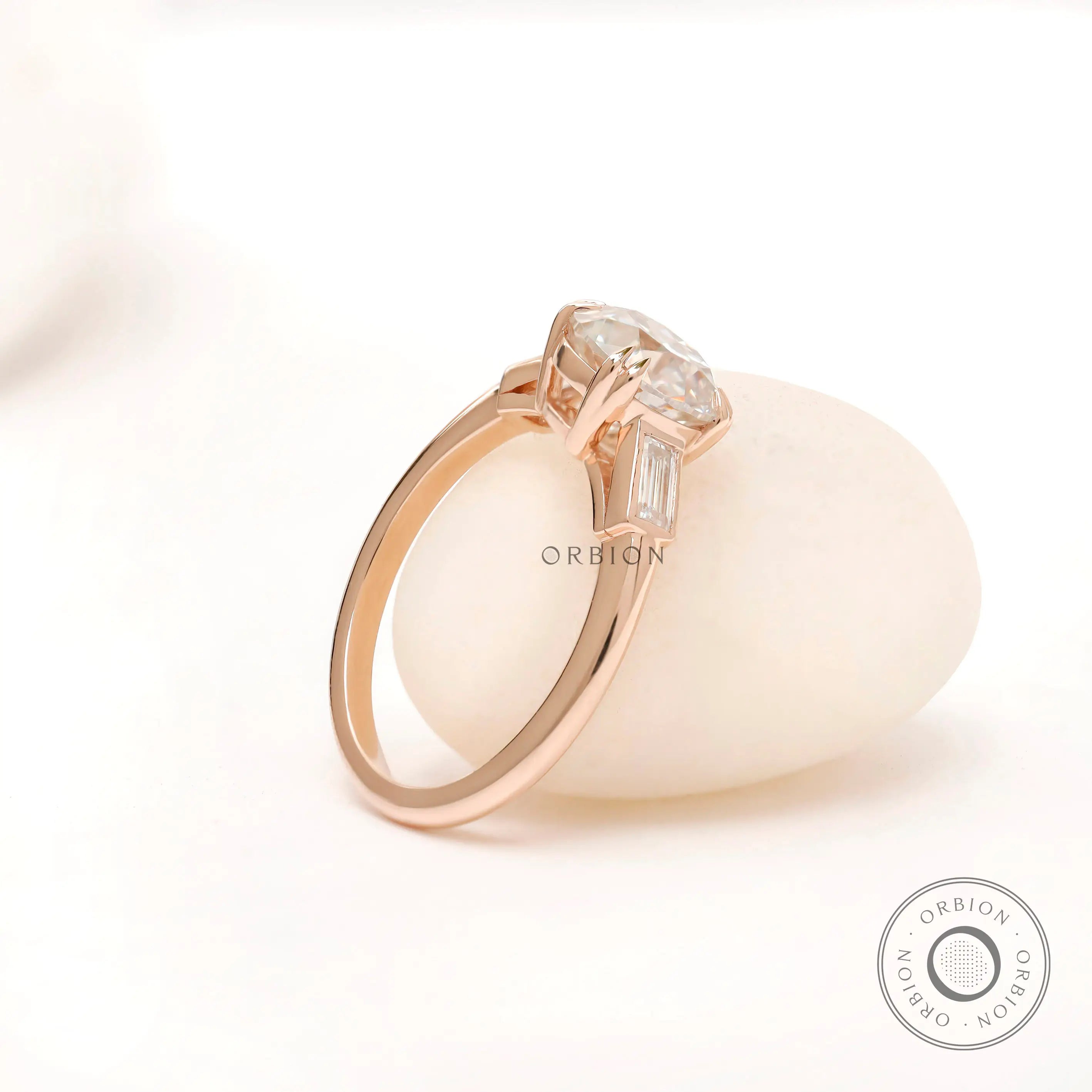Profile of Moissanite three-stone ring with round Old European cut center stone and baguette side stones in 10K yellow gold