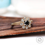 Angled view of black moissanite halo ring with white moissanite accents