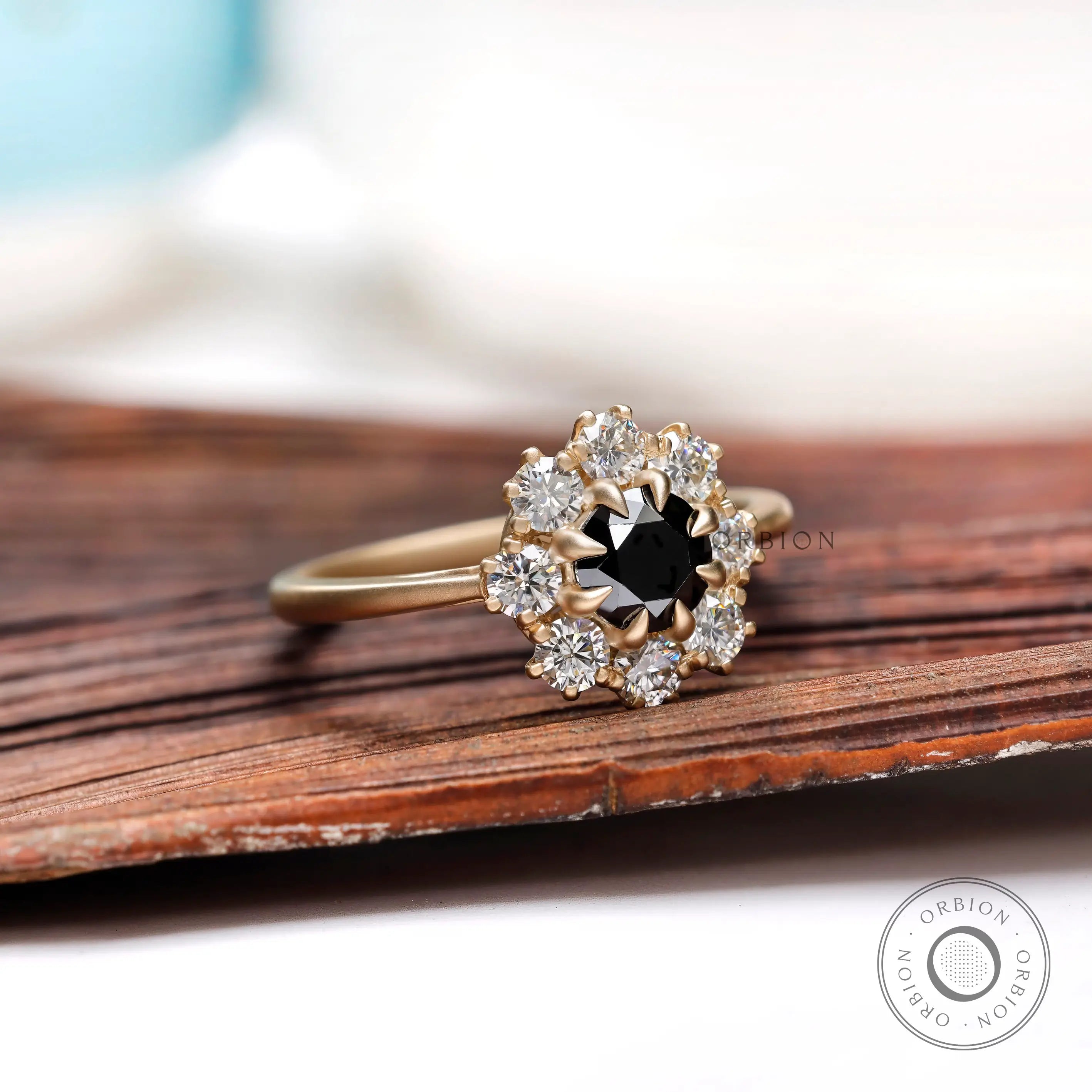 Angled view of black moissanite halo ring with white moissanite accents