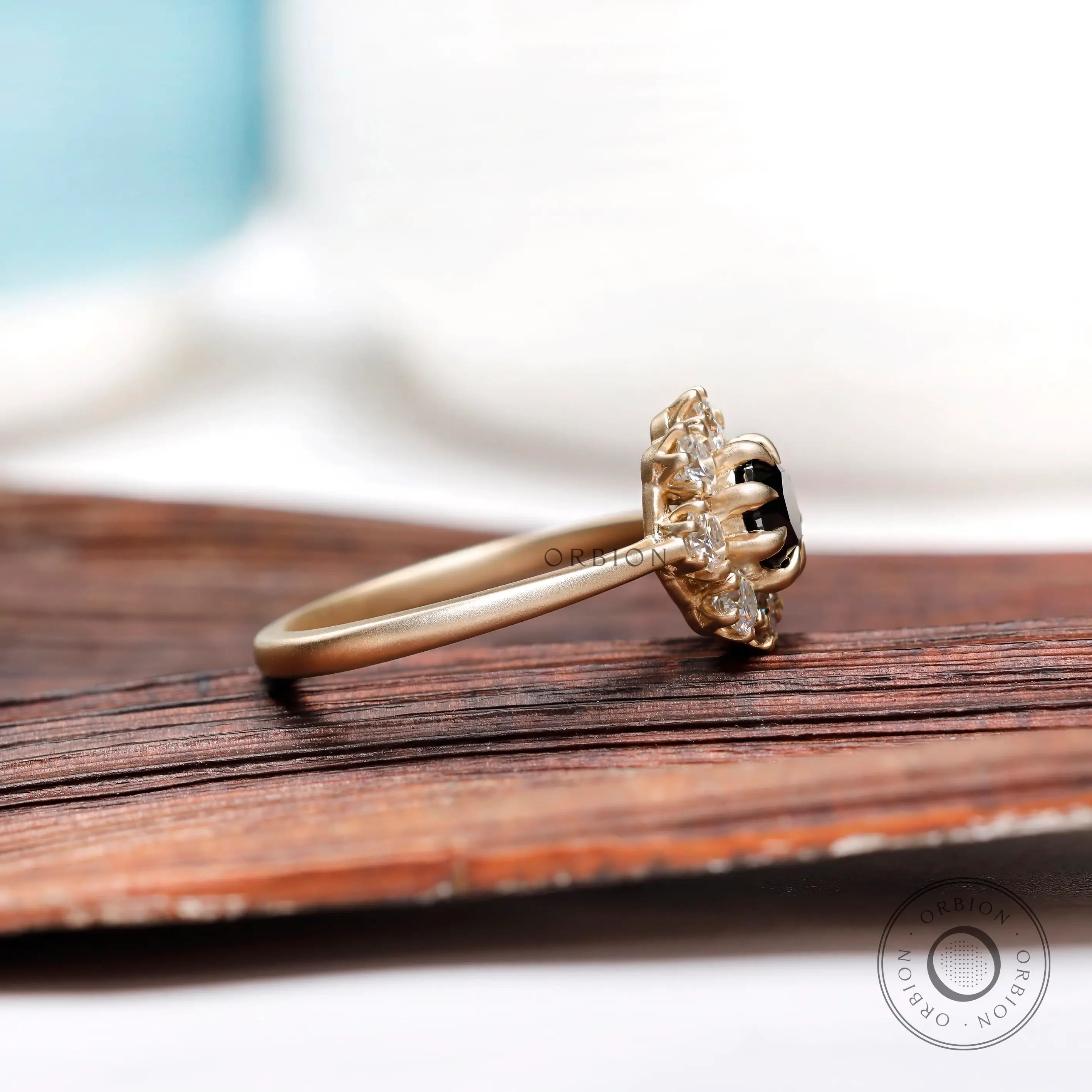 Side profile of black moissanite halo ring in 10K yellow gold