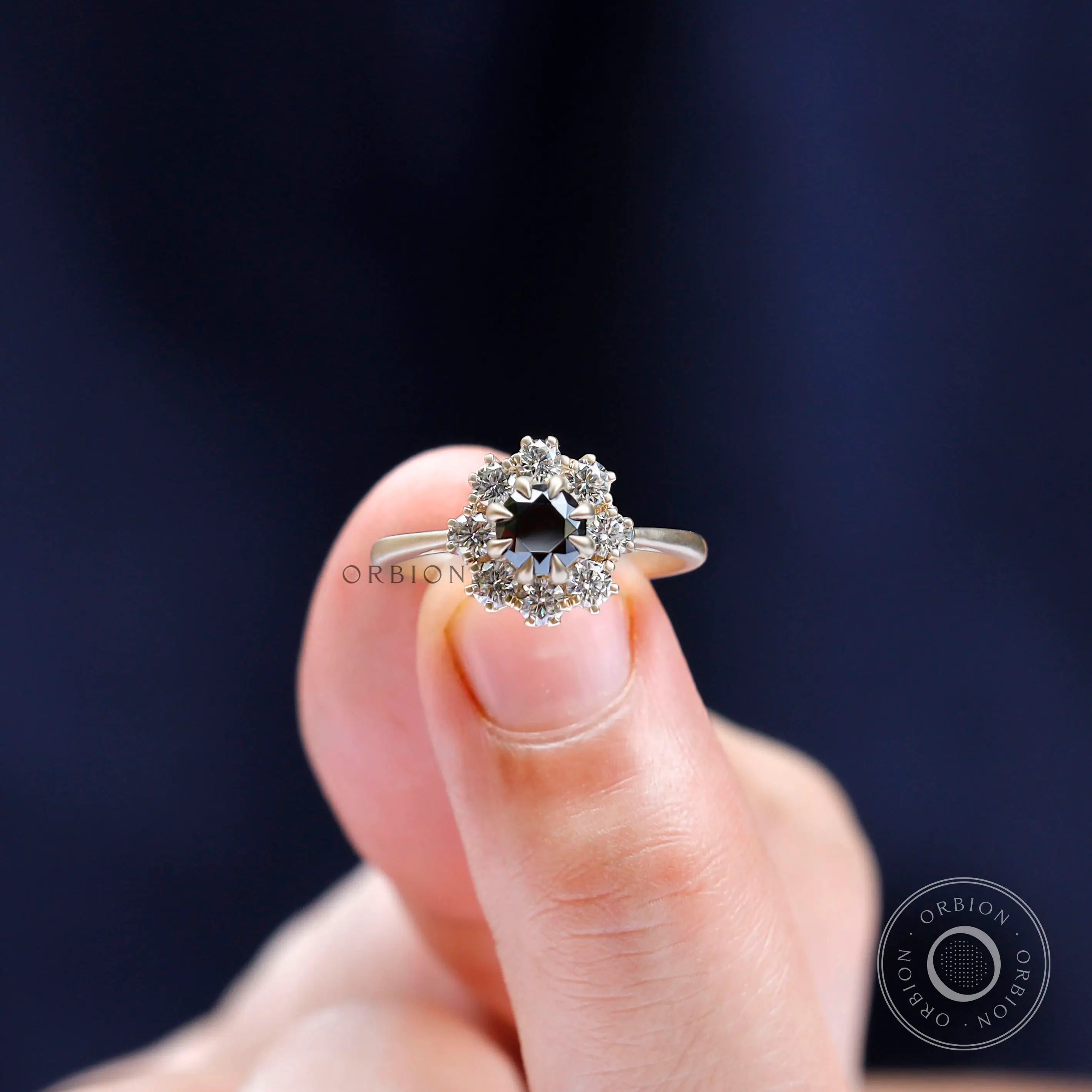 Lifestyle hand shot of black moissanite halo engagement ring